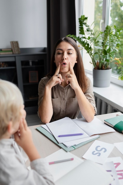 Free Photo young woman doing speech therapy with a little boy