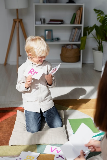 Free Photo young woman doing speech therapy with a little boy