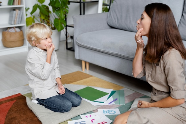 Free Photo young woman doing speech therapy with a little boy