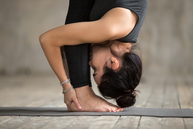 Free Photo young woman doing uttanasana exercise, close up