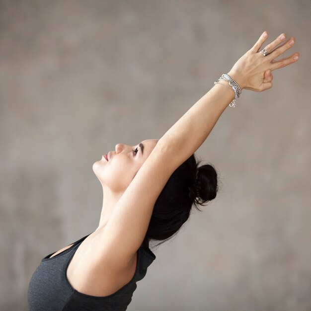 Young woman doing Virabhadrasana 1 exercise