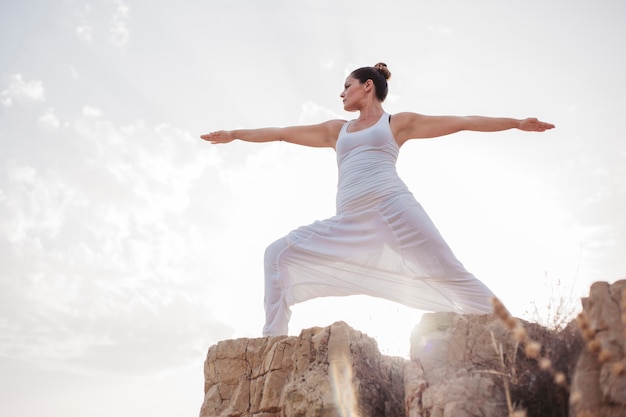 Young woman doing yoga exercise outdoors