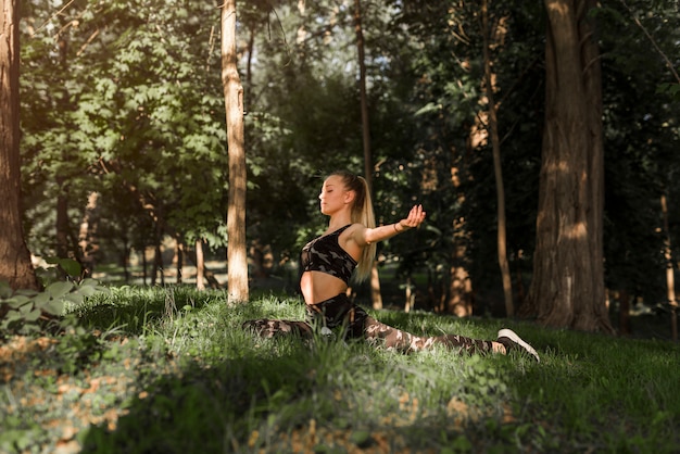 Free Photo young woman doing yoga in the park