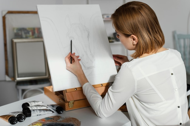 Free Photo young woman drawing on a canvas