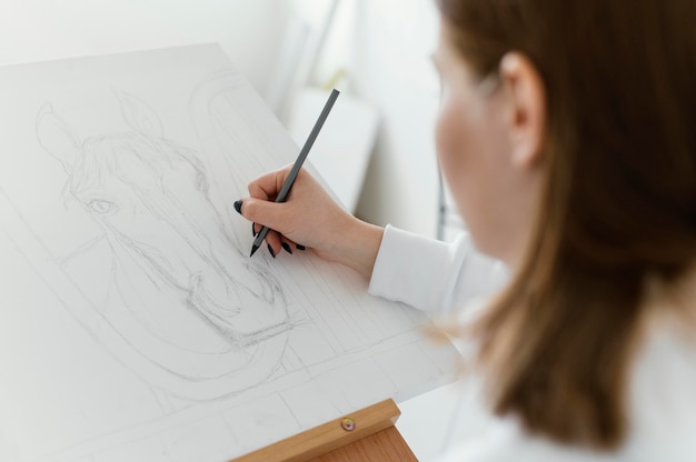 Young woman drawing on canvas