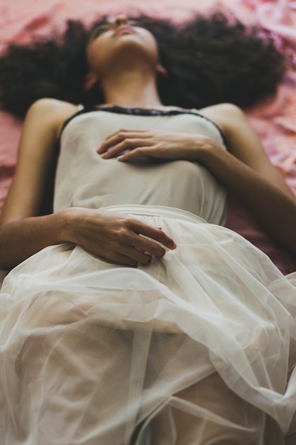 Free photo young woman in dress lying on floor