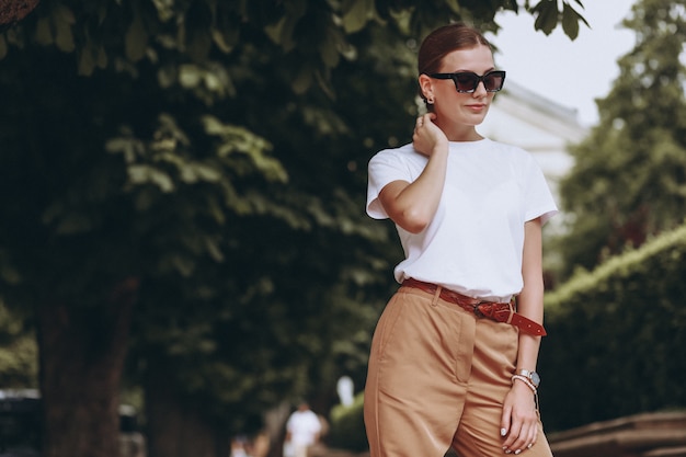 Young woman dressed casual outside in city park