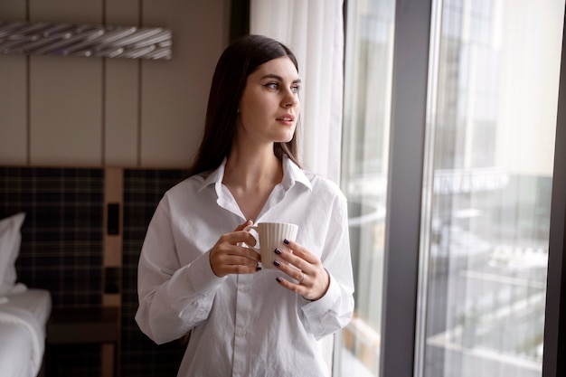 Young woman drinking coffee in a hotel room