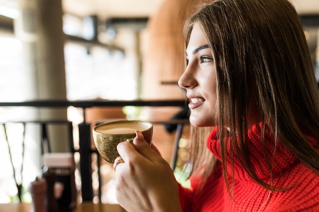 Free photo young woman drinking coffee in the morning at restaurant