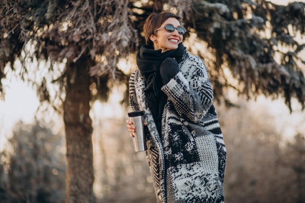 Young woman drinking coffee in the morning and walking in park