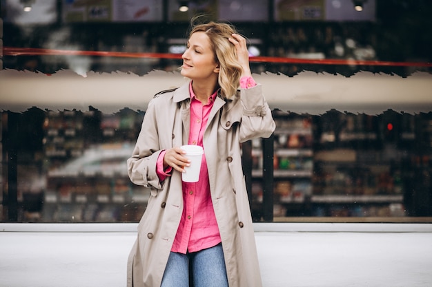 Free photo young woman drinking coffee out in the city