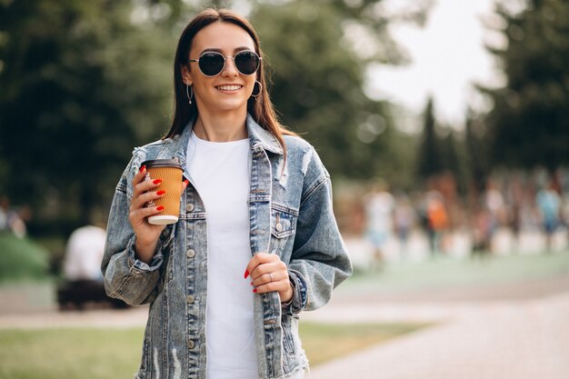 Young woman drinking coffee in park