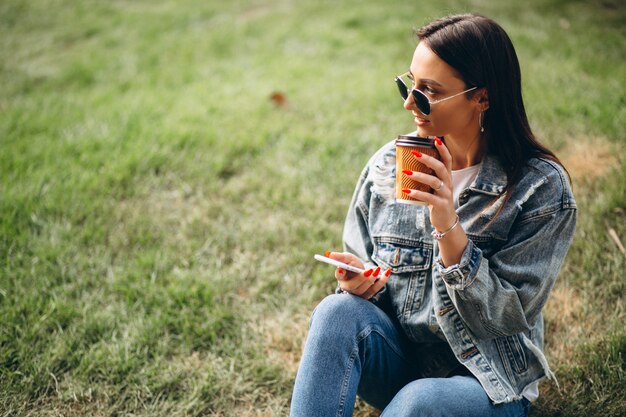 Young woman drinking coffee in park