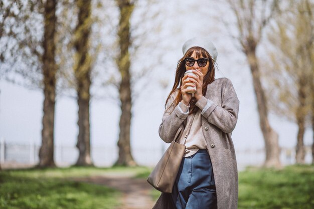 Young woman drinking coffee in park