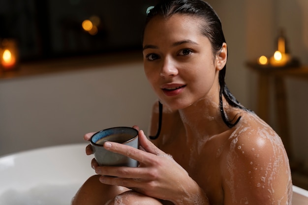 Young woman drinking coffee while taking a bath