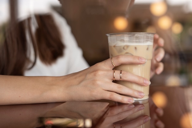 Free photo young woman drinking iced coffee