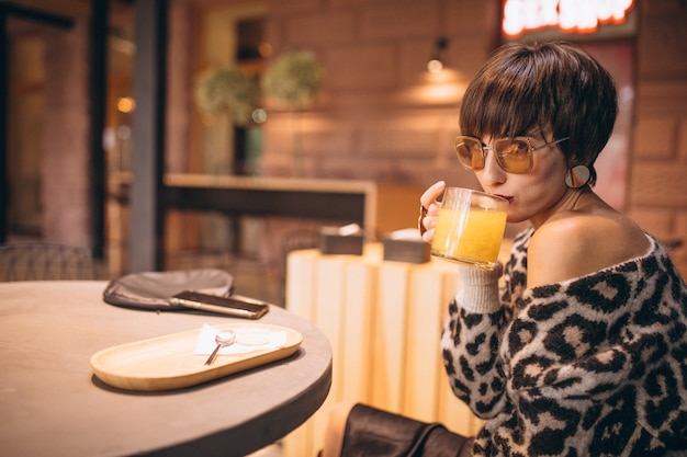 Free photo young woman drinking tea in a cafe