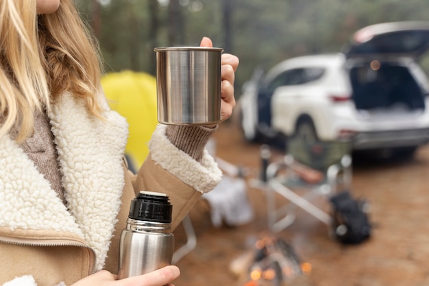 Free photo young woman drinking water while camping