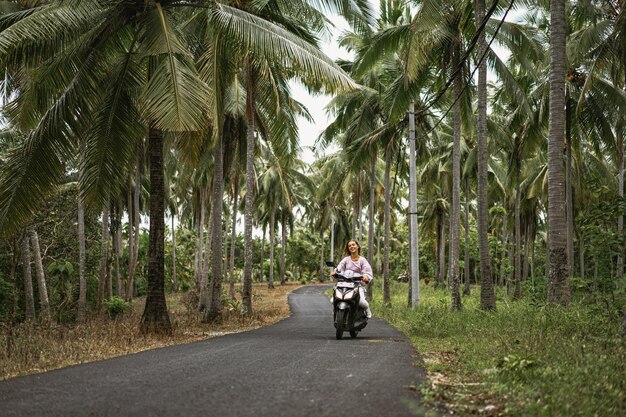 young woman driving a moped tropical life