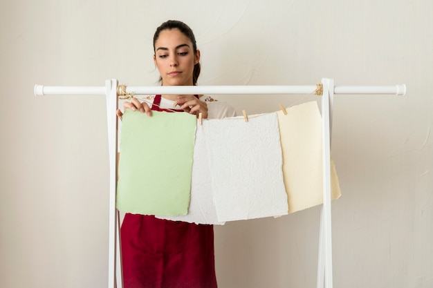 Free Photo young woman drying handmade papers with clothespin