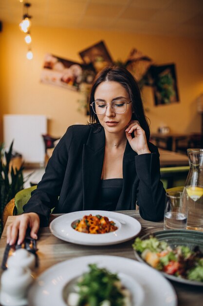 Young woman eating pasta in a cafe