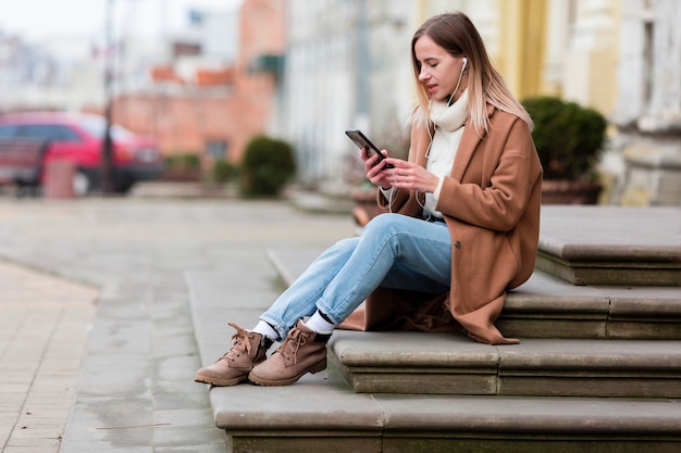 Young woman enjoying the music on earphones in the city