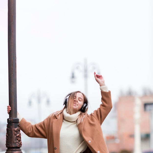 Young woman enjoying the music on headphones in the city