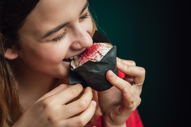 A young woman enjoys a raspberry muffin in a cafe