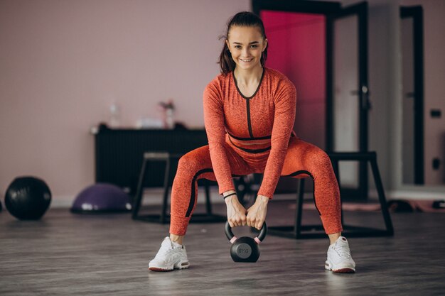 Young woman exercising at the gym with weight