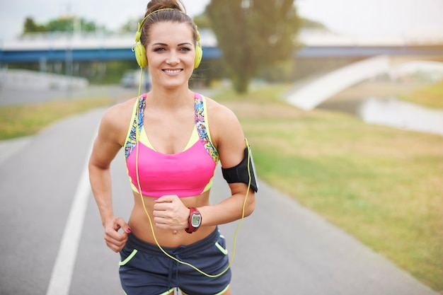 Young woman exercising outdoor. Good weather to go jogging by the river