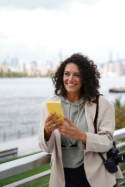 Young woman exploring the city while using a smartphone