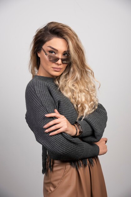 Young woman in eyeglasses looking at her side.