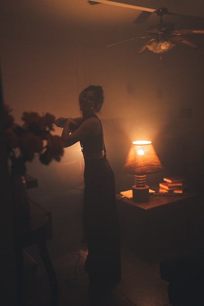 Young woman in eyeglasses standing in a cozy living room