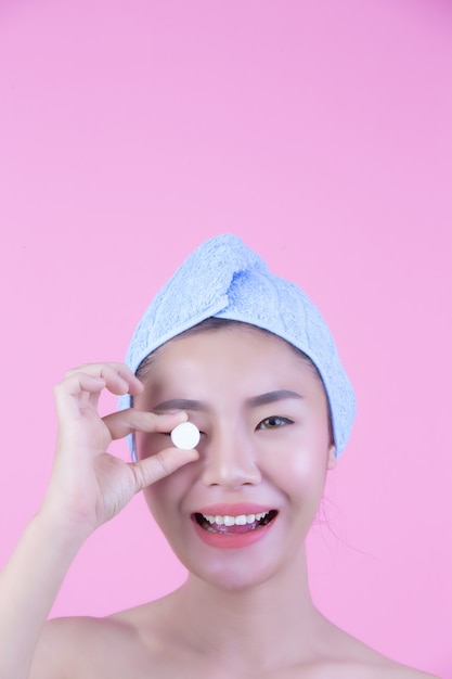 Young woman face mask pad pink background.