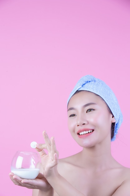 Young woman face mask pad pink background.