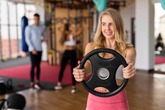 Young woman fitness class with weights