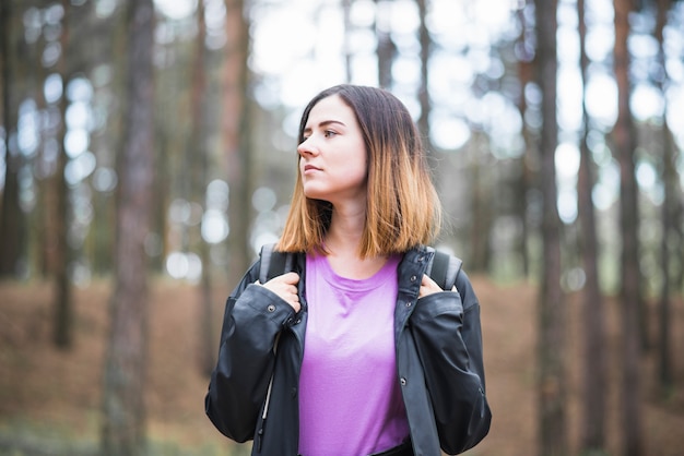 Free photo young woman in forest looking away