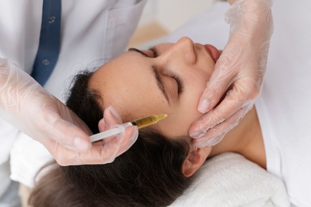 Free photo young woman getting prp treatment high angle