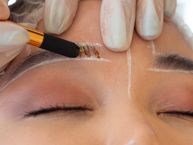 Free photo young woman going through a microblading procedure