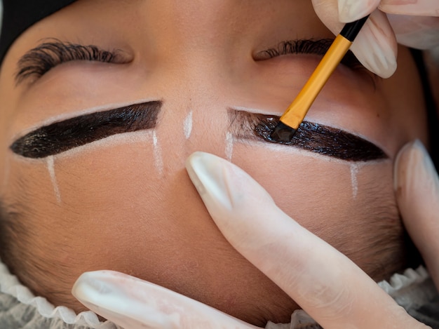 Free photo young woman going through a microblading procedure