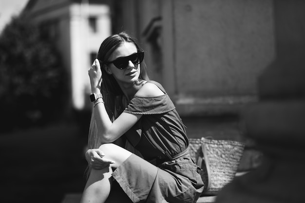 Free Photo young woman in green dress sitting on the stairs of an old building