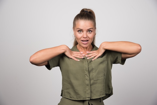 Young woman in green jacket showing herself.