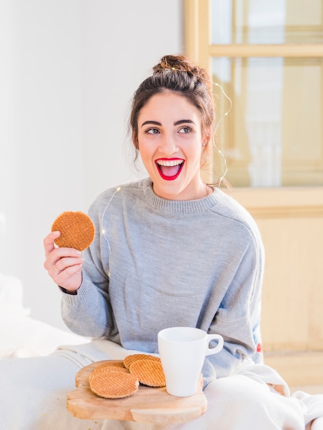 Young woman in grey eating