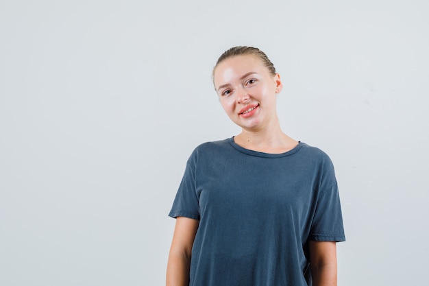 Young woman in grey t-shirt looking and looking positive