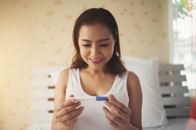 Young woman hand holding pregnancy test 