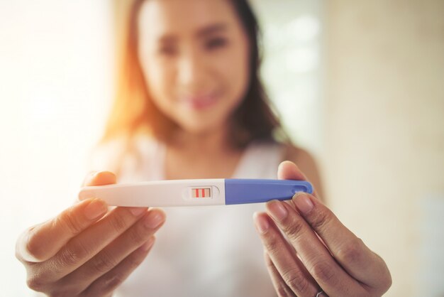 Young woman hand holding pregnancy test 