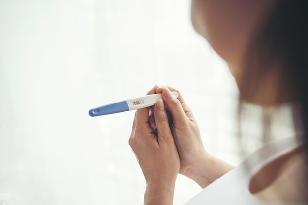 Young woman hand holding pregnancy test 