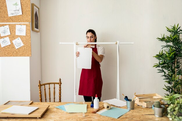 Young woman hanging handmade paper on string