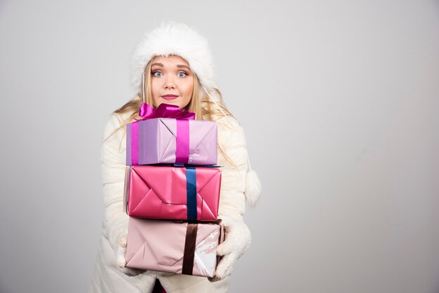 Young woman happily holding gift boxes.