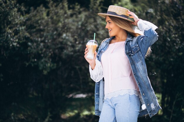 Young woman in hat drinking coffee to go